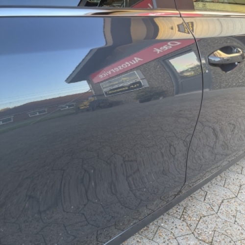 Resultat efter polering af bil med spejlblank lak og tydelig refleksion.